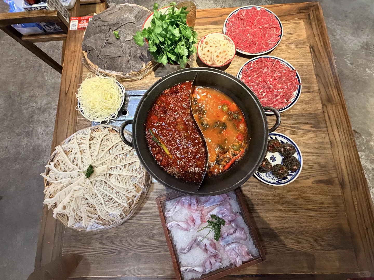bubbling red hotpot with fresh ingredients being added